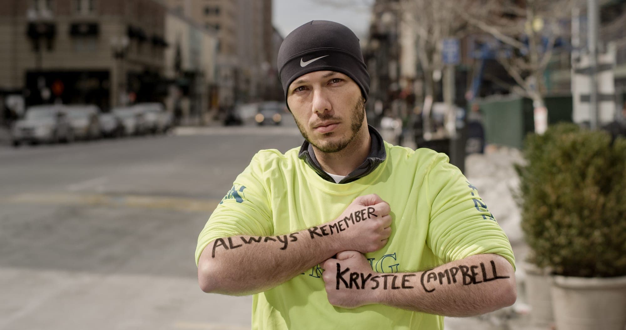 Nick Yanni, Marathon Survivor holding the message "Always remember Krystle Campbell" at the Boston Marathon finish line