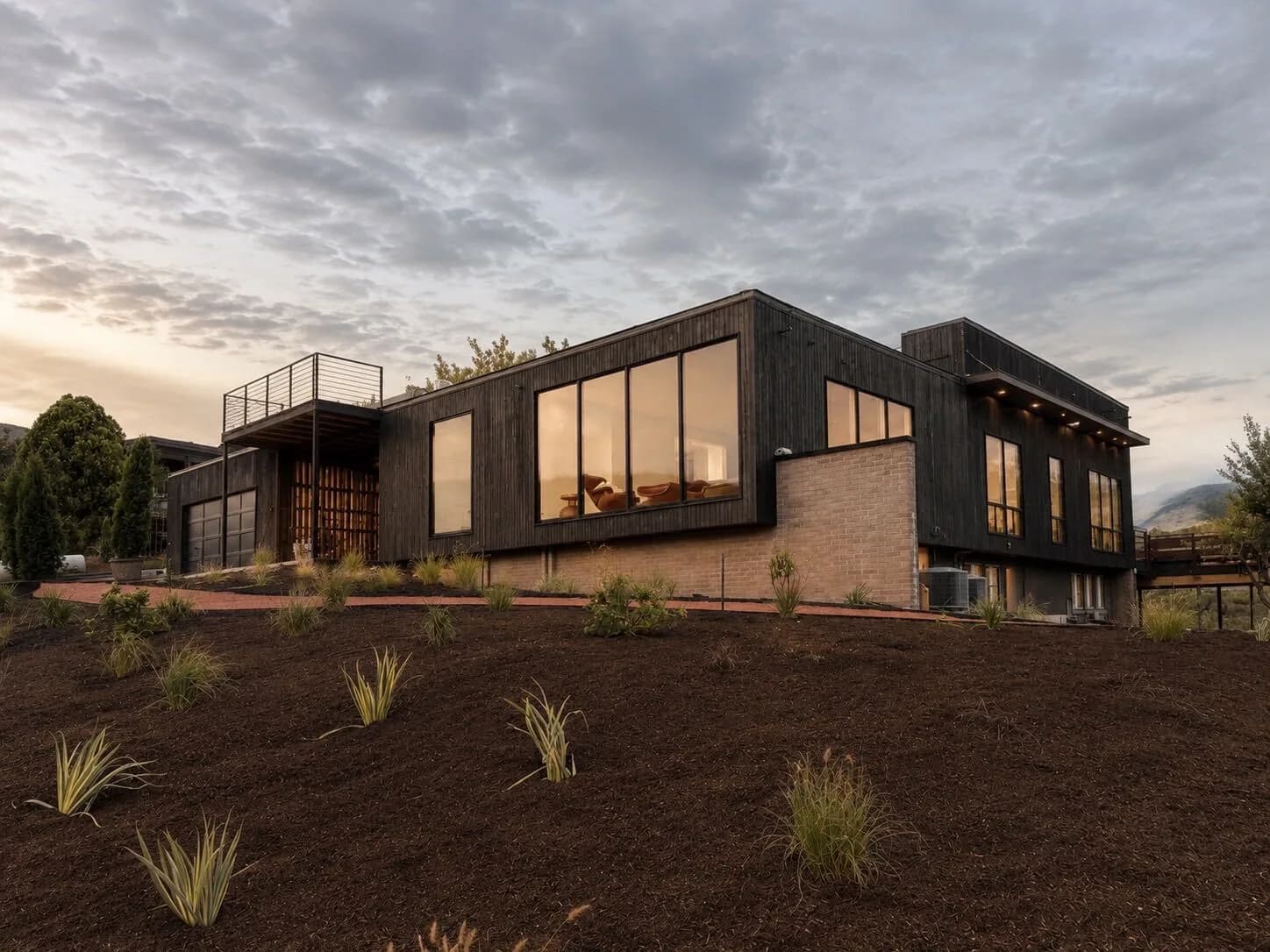 Capitol Hill Clubhouse at dusk, blackened wood above the Salt Lake City hillside